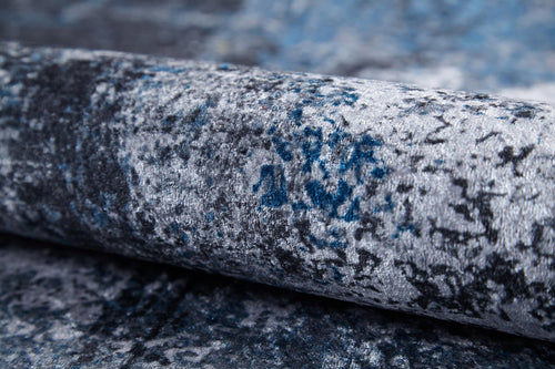 Load image 1 in gallery view. A close-up of the Solar Eclipse - Washable Rug - JR1921 displays its blue and gray mottled velvet texture—soft, plush, and patterned—making it perfect for high-traffic areas and easy to clean.
