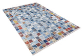 The Square Serenity - Washable Rug (JR1255) features a vibrant blue patchwork of colorful squares in blue, red, yellow, and white on a light background. Its slightly distressed look and durability make it ideal for high-traffic areas.