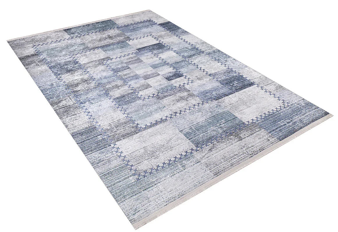 The Tartan Twist - Washable Rug - JR31 features a geometric patchwork design in blue, gray, and white tones with a textured look and rectangular patterns within a bordered frame. Ideal for allergy-sensitive homes. Shown on a white background.