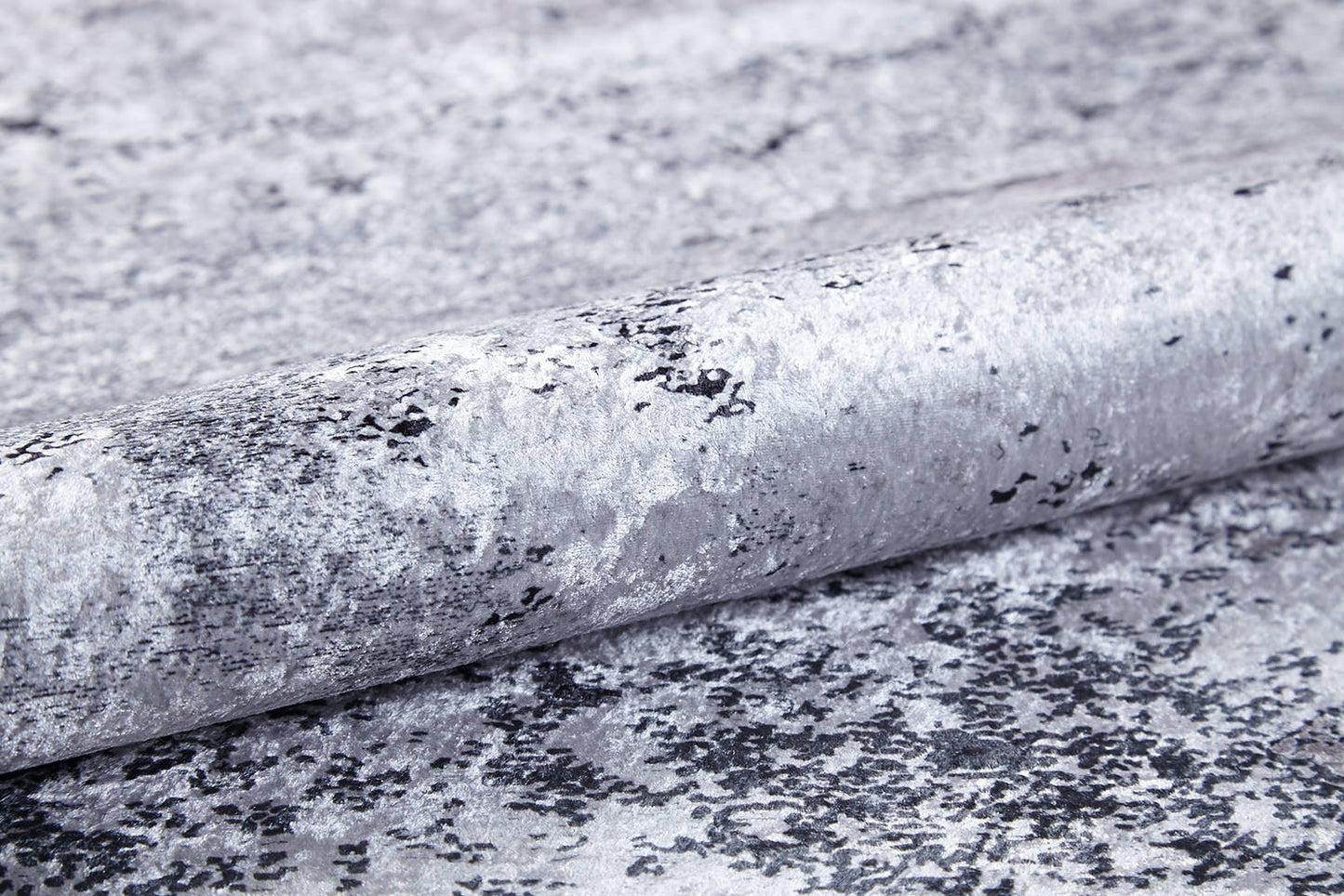 A close-up of textured wallpaper with a metallic silver-gray marbled design and black speckles, a reflective finish, and ideal for pairing with the Techno Flux - Washable Rug - JR1814 to enhance any modern space.
