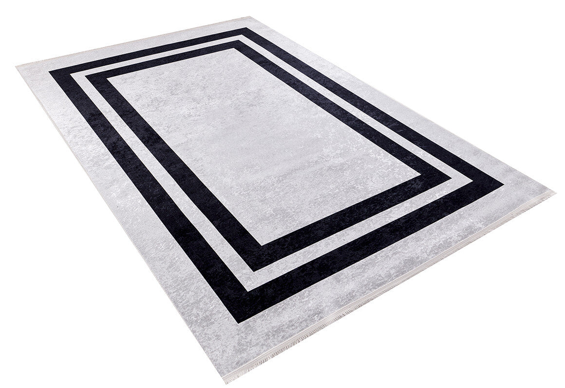 The Timeless Border - Washable Rug - JR572 features a rectangular, durable design with a light gray background and two concentric black borders for a modern geometric look. Shown angled on a white background.