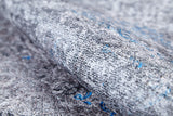 Close-up of the Timeless Embellishment - Washable Rug - JR1943: a textured flat weave in gray and white with blue accents. Its detailed, woven design adds modern flair while being an allergy-friendly, washable rug option.