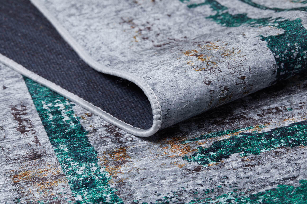 A close-up of the Traditional and Classic - Washable Rug - JR1543 highlights its distressed gray, teal, and rust pattern, with visible texture and detailed stitching along the edge.