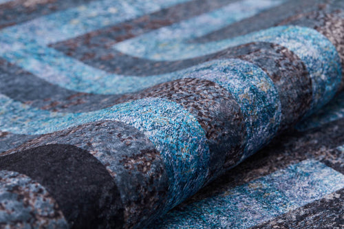 Load image 1 in gallery view. Close-up of the Traditional and Timeless - Washable Rug - JR1408, rolled to show its textured, looped pattern in blue, gray, and black with a modern abstract geometric design—perfect for high-traffic areas.