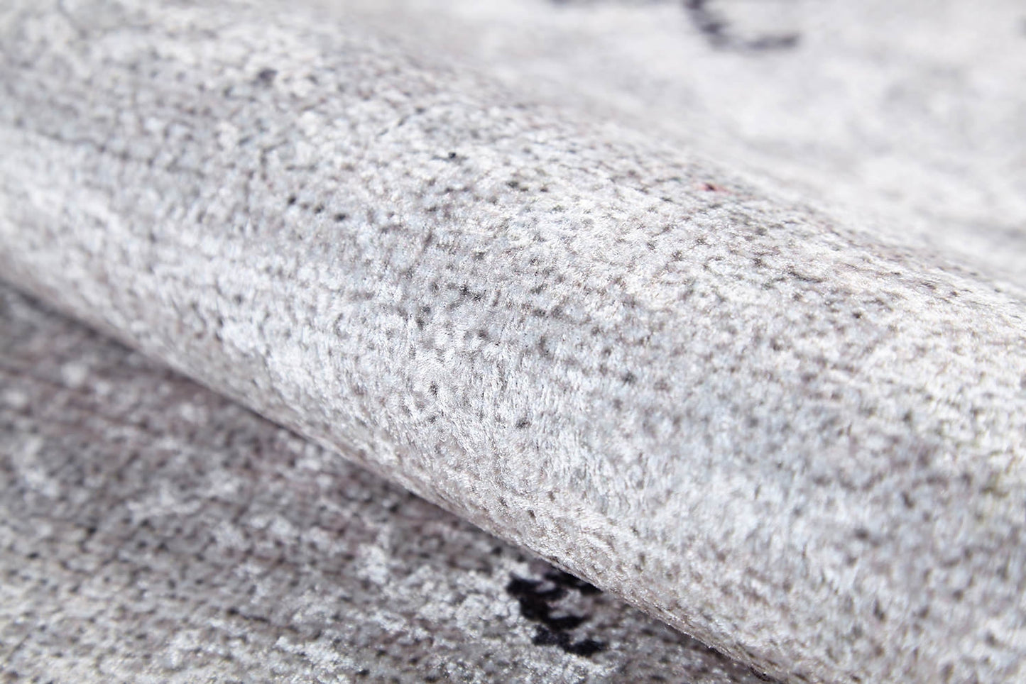 Close-up of the Tribal Tassel - Washable Rug - JR1683 in light gray, cream, and beige highlights its soft, plush feel and subtle speckled pattern. Slightly rolled or folded, this washable rug suits high-traffic areas perfectly.