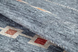 Close-up of the Tuscan Villa - Washable Rug - JR5058: a textured gray-anthracite rug with red and beige diamond patterns linked by beige lines. Partially folded to show its plush, thick surface—ideal for high-traffic spaces.