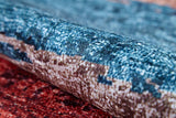 A close-up of the Urban Edge - Washable Rug - JR2005, showing its soft, thick texture and woven fibers in vibrant blue, brown, and red shades with a multicolor pattern.