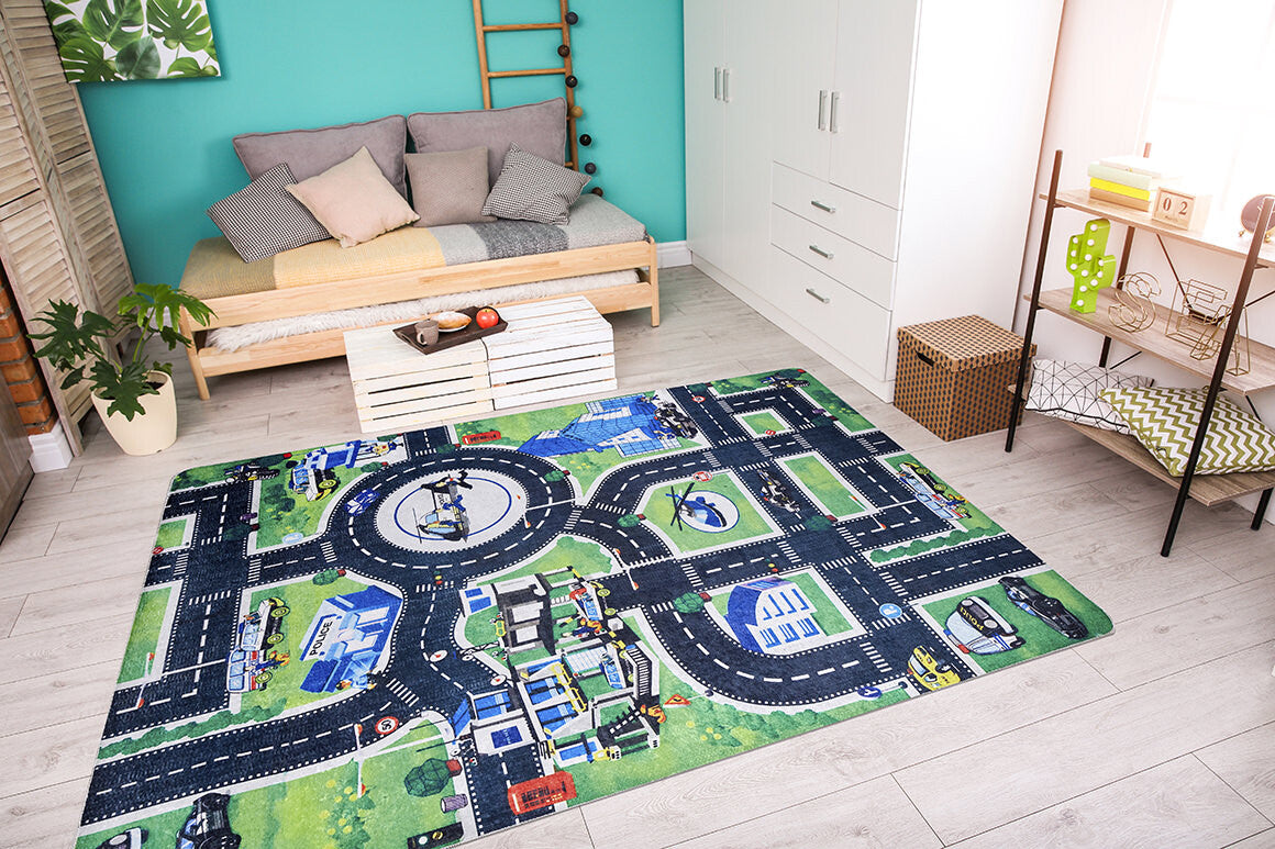 A bright, modern living room with a gray sofa, pastel cushions, wooden coffee table, white cabinets, and the Urban Road - Machine-Washable Rug JRC013 featuring roads, buildings, and cars on a light wood floor.