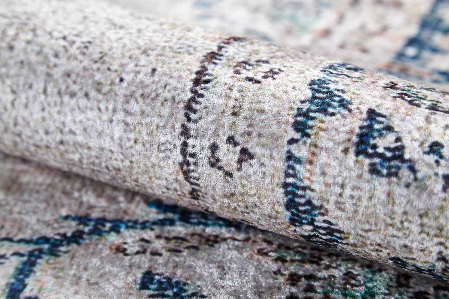A close-up of the Vintage Beauty - Washable Rug - JR1688 shows its rolled, textured surface and subtle faded beige, blue, and gray pattern. The soft plush fabric is perfect for allergy-sensitive homes and high-traffic areas.