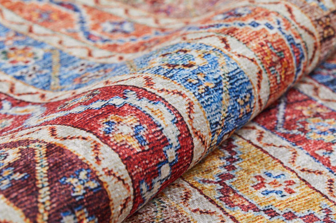 Close-up of the Vintage Vibes - Washable Rug - JR37, featuring intricate multicolor geometric patterns in red, blue, yellow, and beige with detailed texture and a slight fold—ideal for adding vibrant style to high-traffic spaces.
