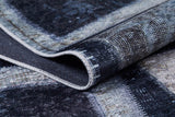A close-up of the Windowpane Wonder - Washable Rug - JR184 shows its folded, textured flat weave with dark blue, gray, and white rectangles and visible edge stitching.