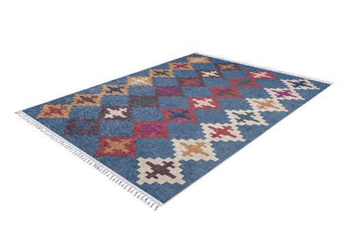 Load image 1 in gallery view. The Nomad's Mirage - Washable Rug - JR5032 is a rectangular blue-base rug with a grid of red, white, yellow, and purple geometric patterns and short white fringe on both ends. It’s ideal for high-traffic areas.
