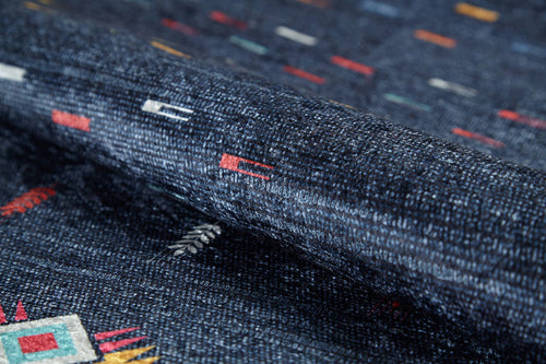 Load image 1 in gallery view. The Wanderer's Way - Washable Rug (JR5101) is a dark blue rug with small geometric patterns in red, white, yellow, and turquoise. Its textured, slightly raised surface is ideal for high-traffic areas and easy to clean.